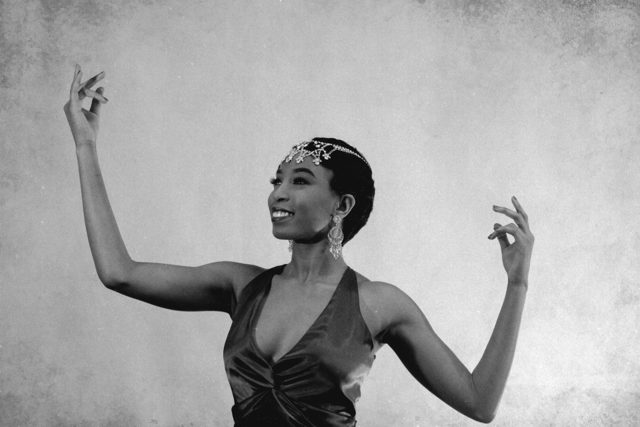 Black and white photo of Aerie Williams dancing in a jeweled headpiece